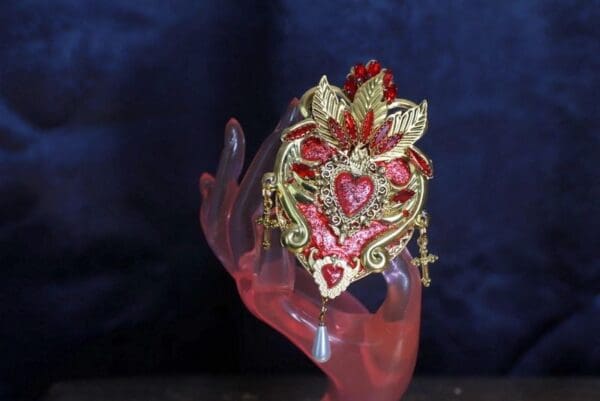 A hand holding something with a heart on it
