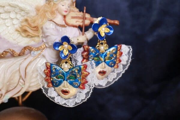 A pair of earrings with blue and white masks on them.