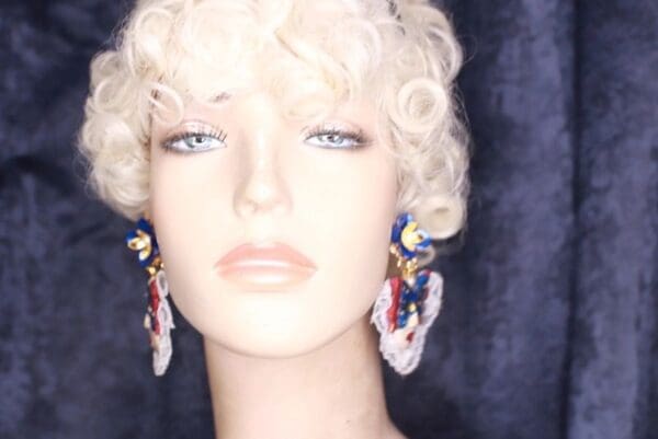 A mannequin head with long earrings and curls.