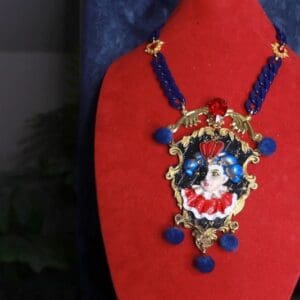 A red and blue necklace with a clown face on it.