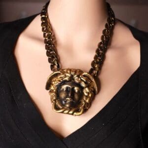 A woman wearing a necklace with a face on it.