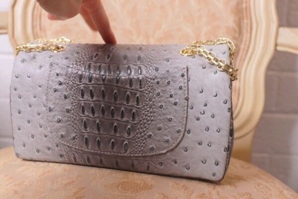 A person is touching the side of a purse.