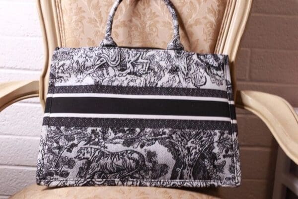 A black and white bag sitting on top of a chair.
