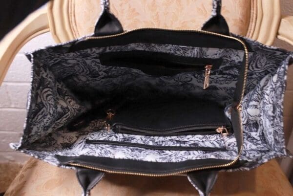 A black purse with two compartments and one has a zipper.