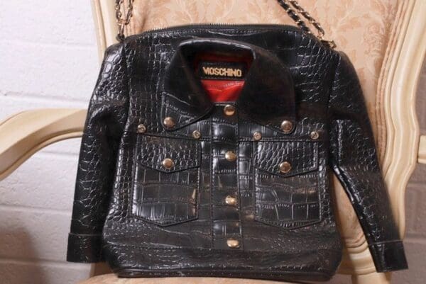 A black leather jacket with gold chain on top of it.