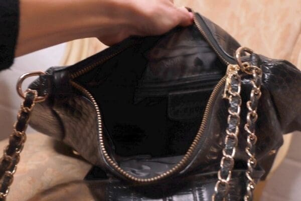 A person holding onto the inside of a purse