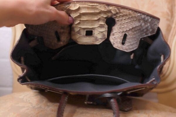 A person holding an open purse with the inside of it.