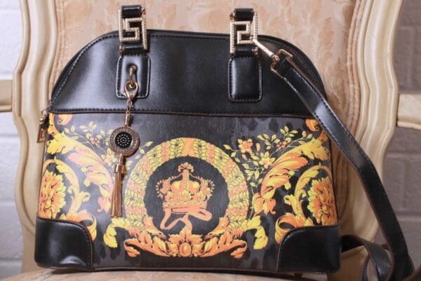 A black purse with gold and yellow designs on it.
