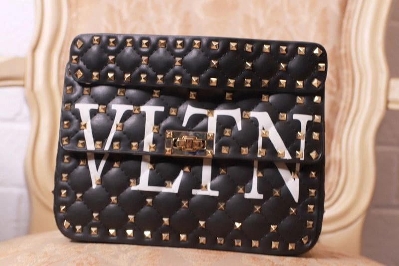 A black and white bag with gold studs on it
