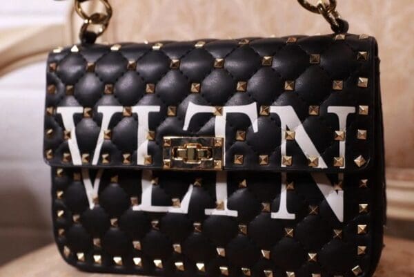A black and white bag with gold chain