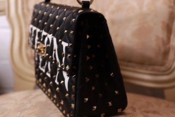 A black and white bag with gold studs on it