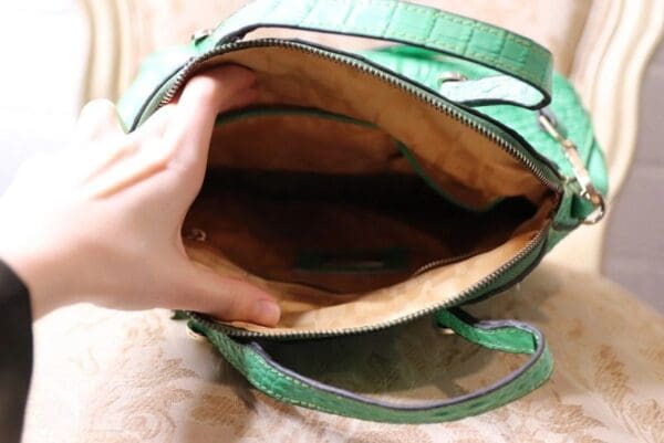 A person opening up an empty purse.