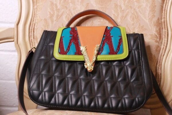 A black purse with colorful accents on it.