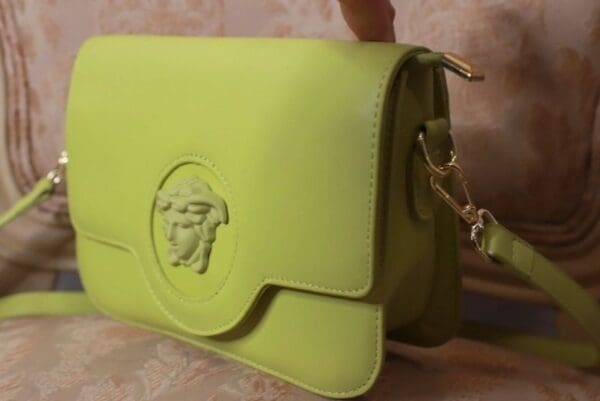 A person holding onto a lime green purse