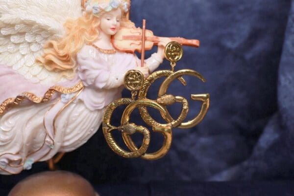 A close up of a pair of earrings on a figurine