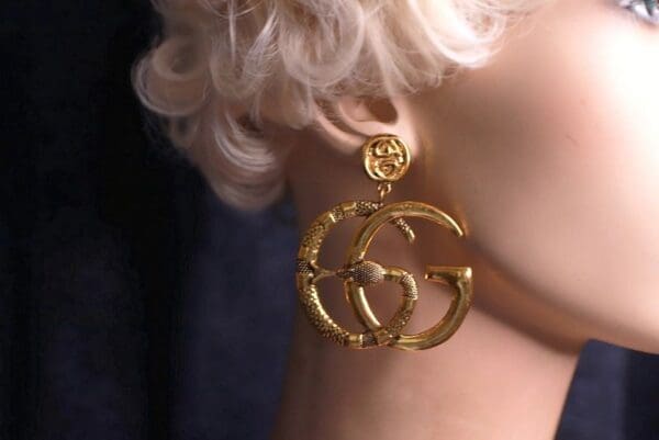 A woman with blonde hair wearing gold earrings.