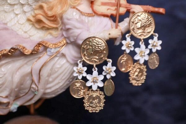 A close up of some earrings with flowers and coins
