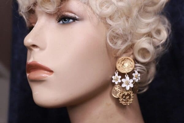 A woman with blonde hair wearing earrings and a white wig.