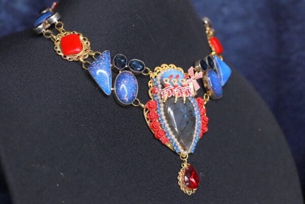 A necklace with blue and red stones on it.