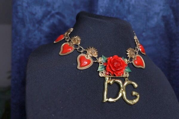 A necklace with red roses and hearts on it.