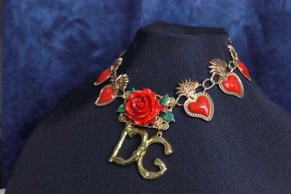 A necklace with red roses and hearts on it.