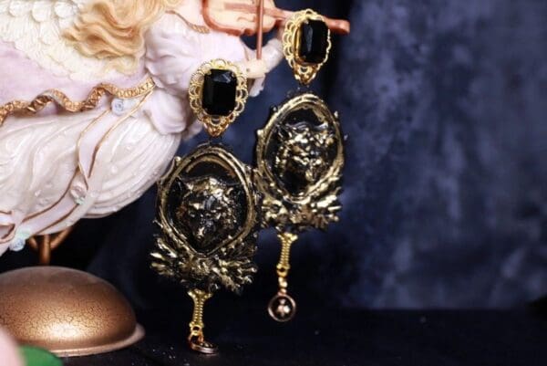 A pair of hand mirrors with black and gold designs.