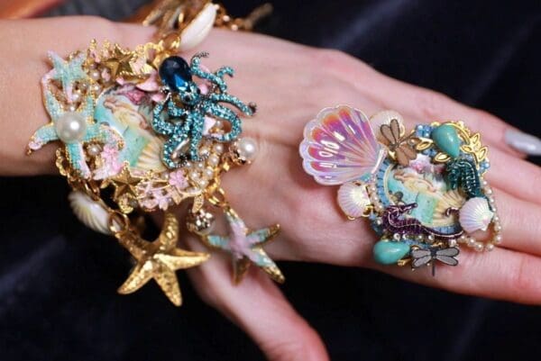 A hand with many different jewelry on it