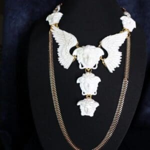 A necklace with white skulls and chains on it.