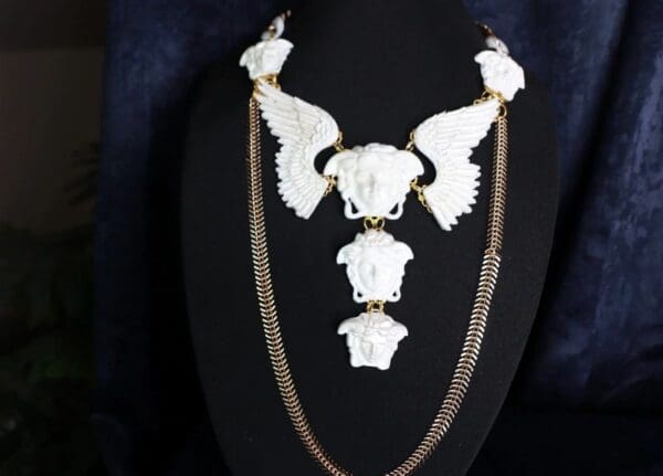 A necklace with white skulls and chains on it.