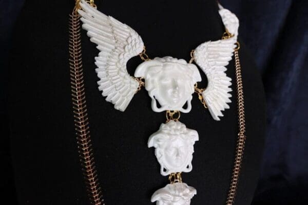 A necklace with white statues of winged heads.