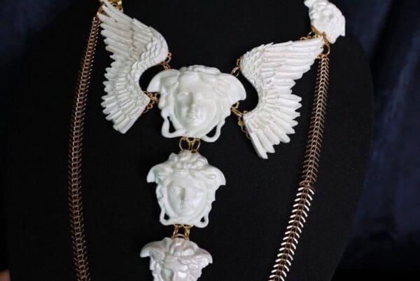 A necklace with white elephants and wings on it.