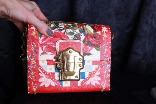A woman holding onto the handle of her purse.