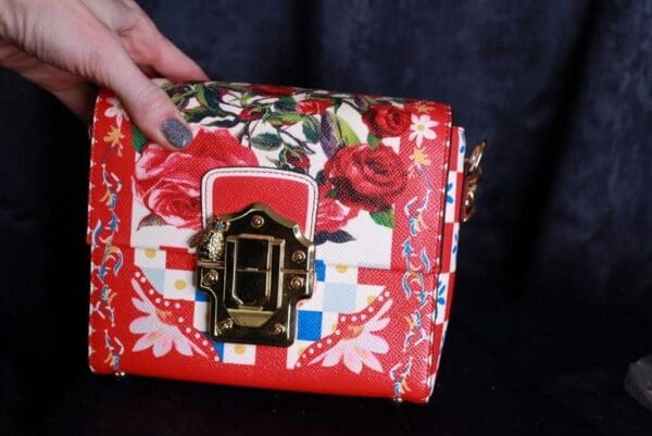 A woman holding onto the handle of her purse.