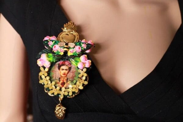 A woman wearing a necklace with flowers and a picture of frida kahlo.