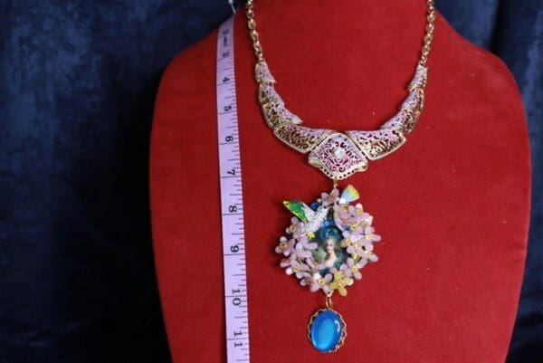 A necklace is shown on the bust of a mannequin.