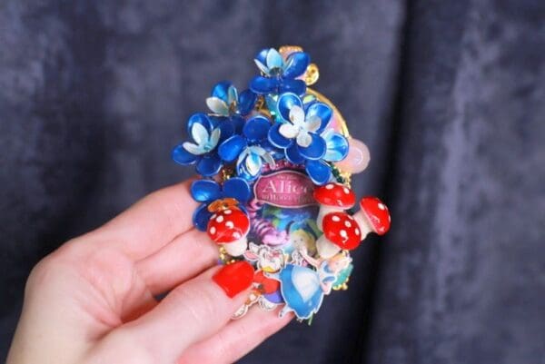 A person holding onto some blue flowers and red dice
