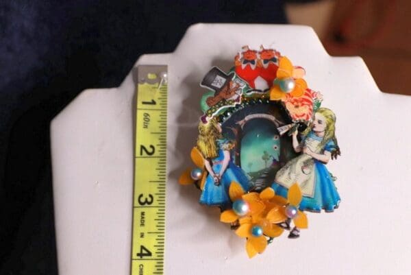 A small picture frame with a ruler and some flowers
