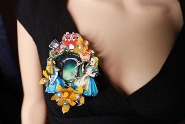 A woman wearing a brooch with colorful flowers and birds.
