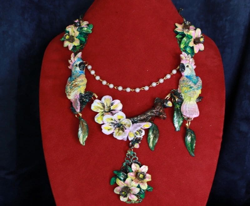 A red display stand with a necklace and earrings