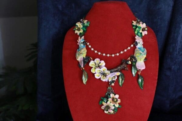 A red display stand with a necklace and earrings on it.