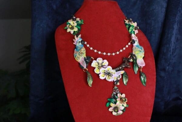A red display stand with a necklace and earrings.