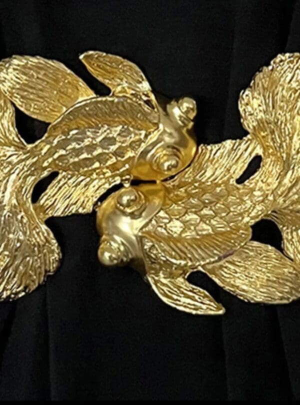 A close up of two gold fish on top of leaves.