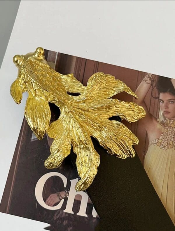 A gold leaf is on top of the book.