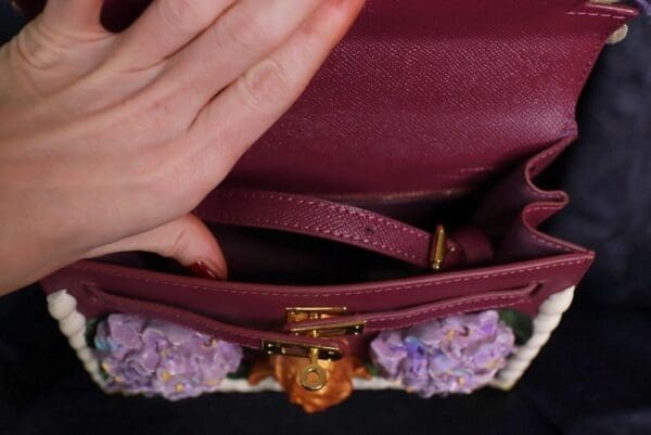 A person holding onto the handle of a purse