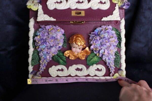 A purple box with a cherub and flowers on it.