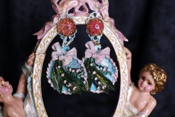 A pair of earrings hanging from the side of a mirror.