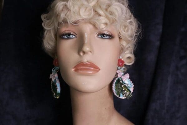 A mannequin with short blonde hair and pink earrings.