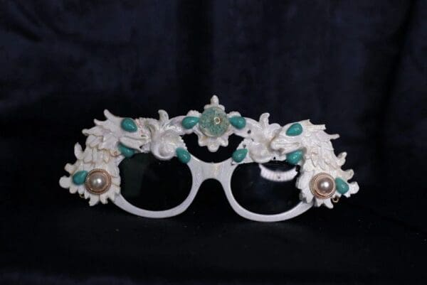 A pair of glasses with flowers and pearls on them.