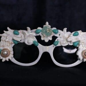 A pair of glasses with faces and flowers on them.