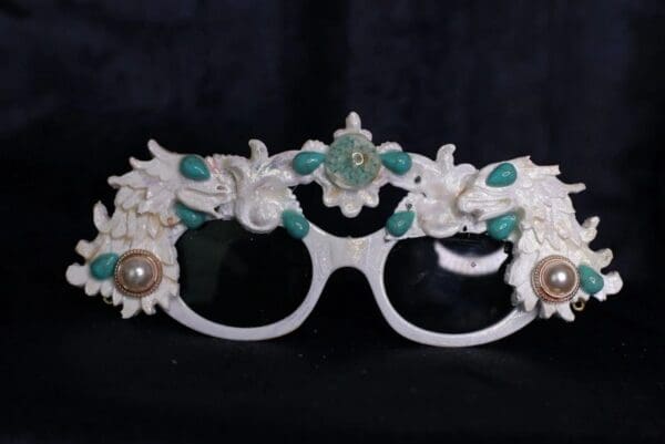 A pair of glasses with faces and flowers on them.